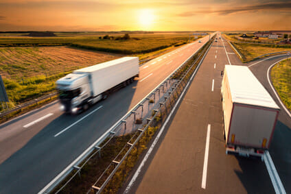 Two trucks on highway in motion blur
